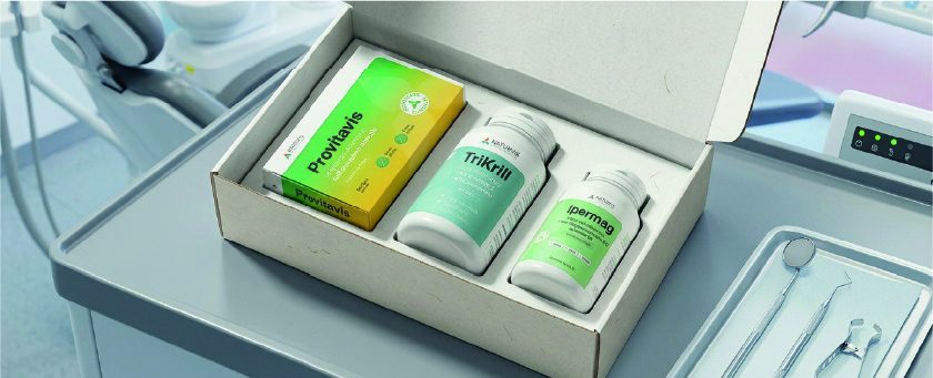 La confezione OdontoBox aperta su un piano da studio odontoiatrico, con Provitavis, TriKrill e Ipermag
